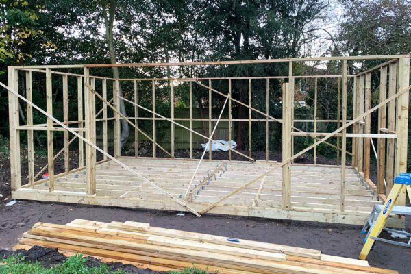 Close up of two unrecognizable architects pointing at floor plan while working on blueprints at workplace, copy space